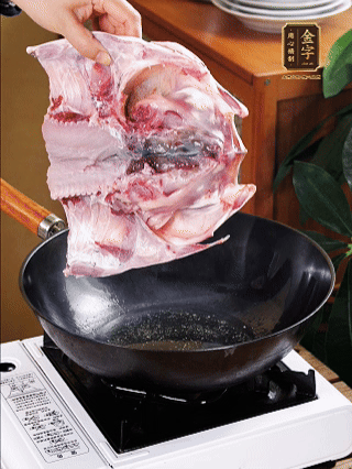 锅里油烧热（一半猪油、一半玉米油），放入鱼头，把鱼头煎至少两面金黄